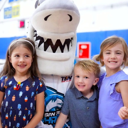 Chomp the shark with kids at a basketball game