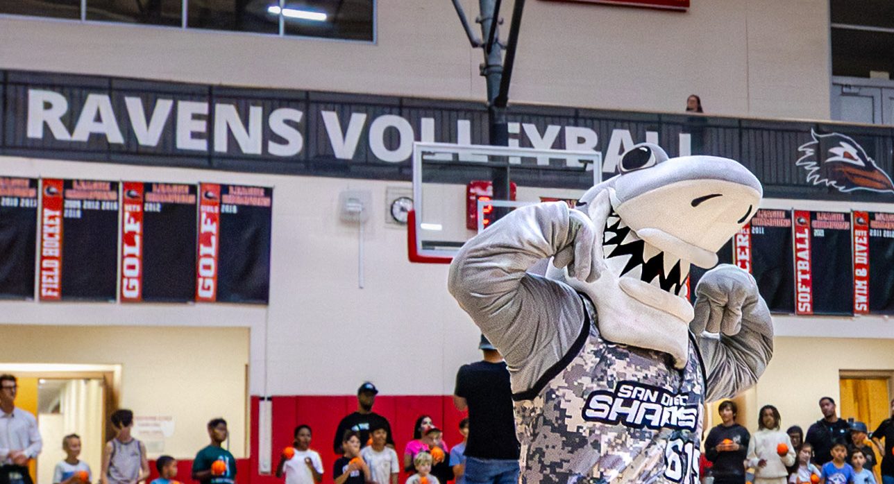 Crunch the Sharks mascot flexing at center court