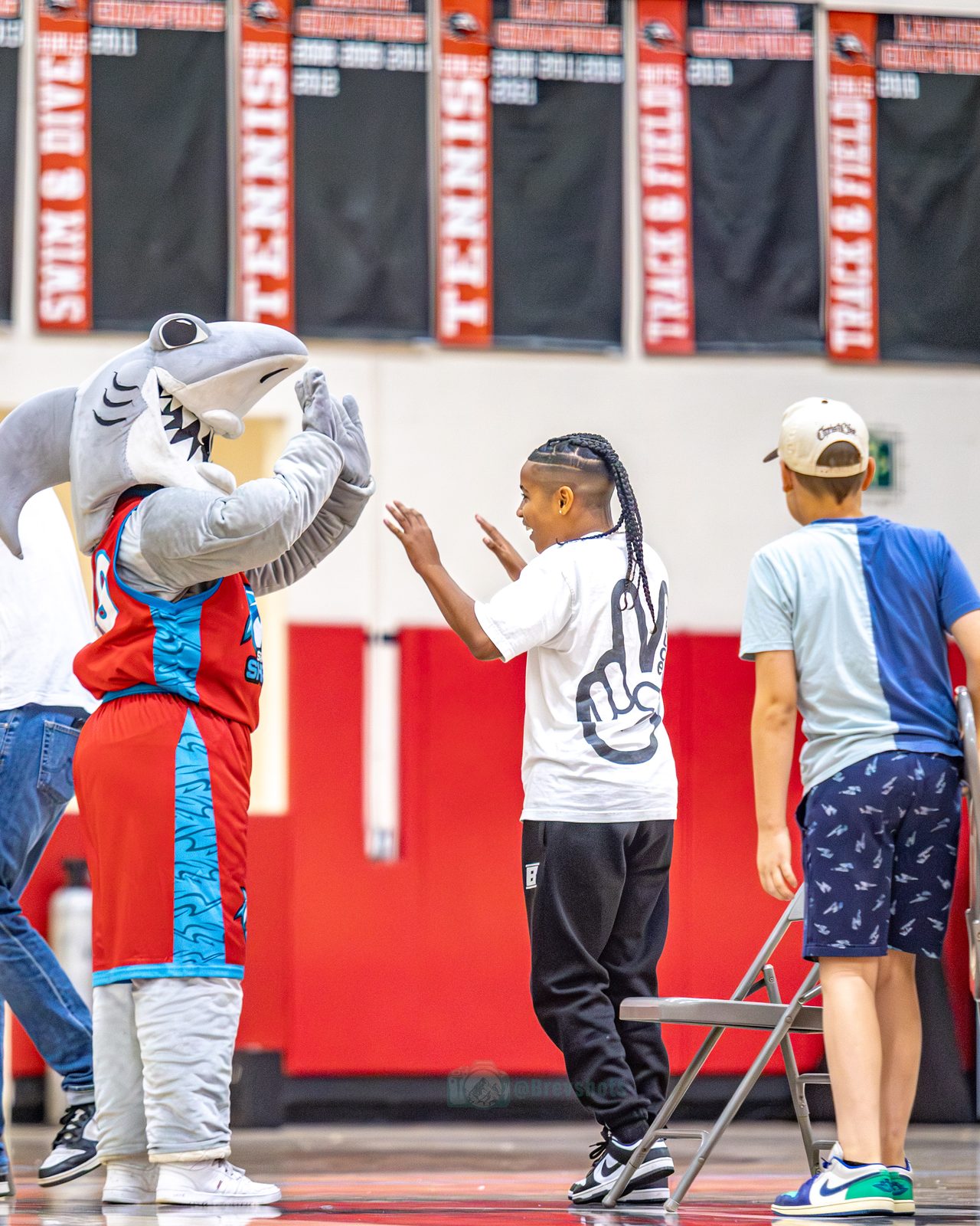 Crunch trading high fives with two kids on the baseline