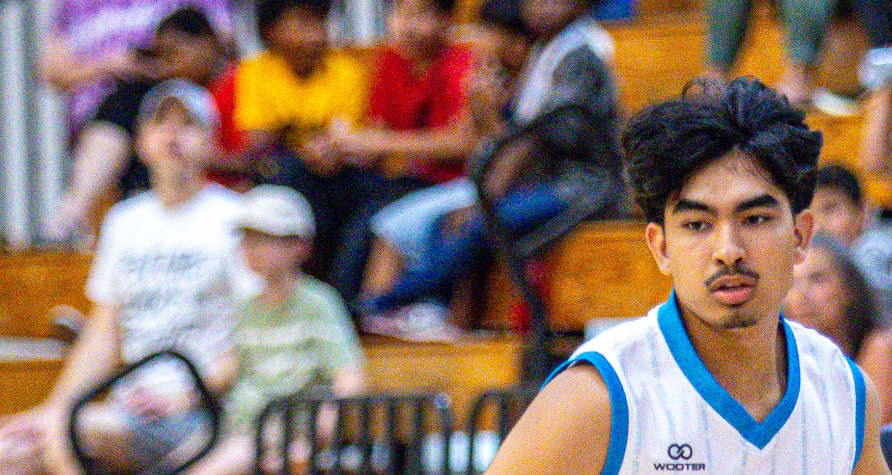 A Sharks guard brings the ball up in front of families in the bleachers